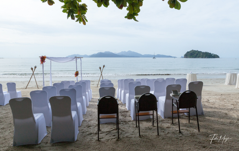 Aufgereihte Stühle und Gestell für Strandhochzeit