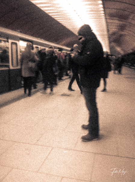Mann mit Handy in Münchner  U-Bahn Station