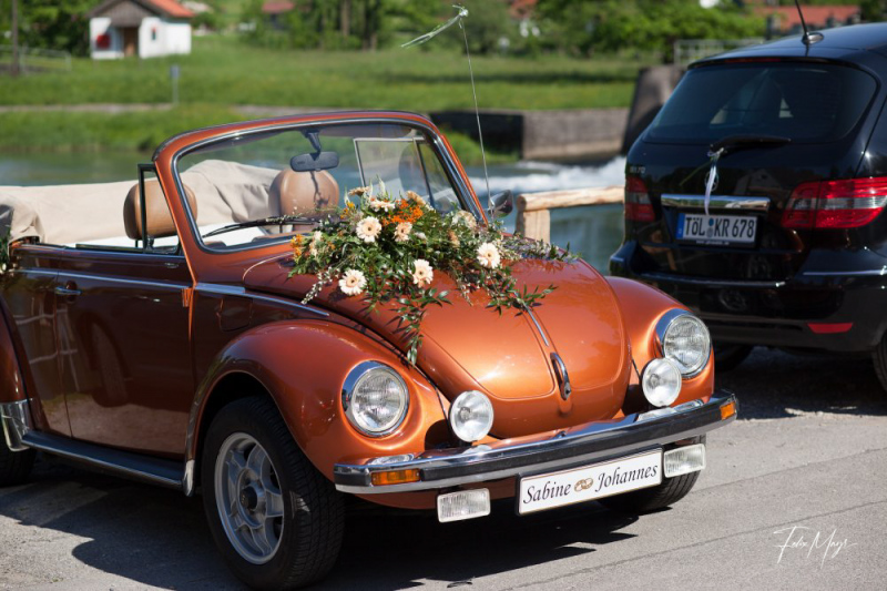 Bronzefarbenes Käfer Cabriolet geschmückt mit Hochzeitsblumen