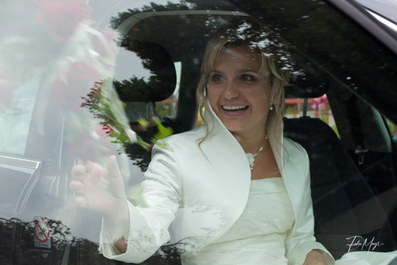 Braut auf Beifahrersitz hinter Fensterscheibe