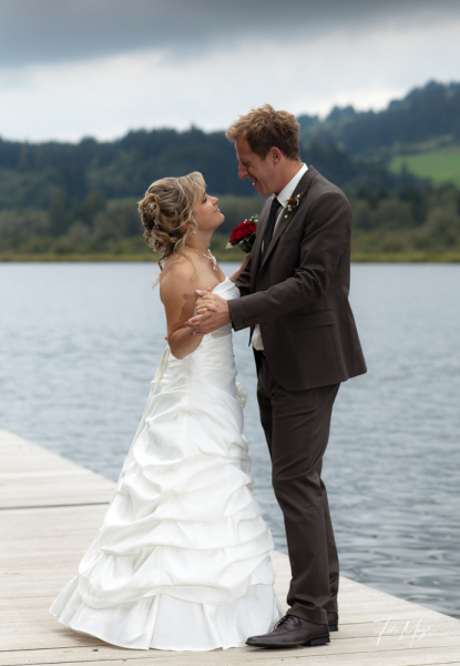 Brautpaar tanzt auf Steg an einem See