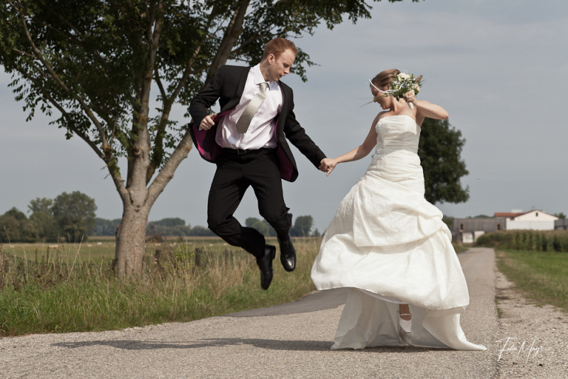 Brautpaar springt Händchen haltend in die Luft