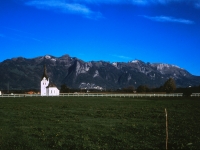 Kirche mit Zaun vor Bergmassiv