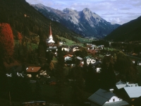 Dorf mit Kirche vor Bergmassiv