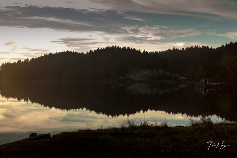 Sonnenuntergang spiegelt sich im Wasser am Kirchsee