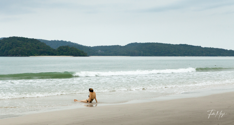 Frau sitz einsam am Strand in den Wellen