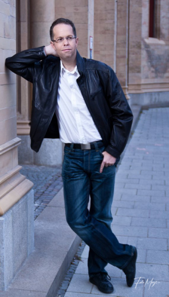 Lässig stehender Mann mit Lederjacke und Jeans