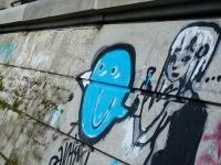Blaues Graffiti eines Smilies auf Mauer