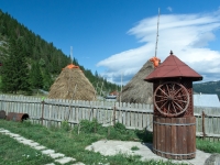 Nach alter Tradition aufgeschichtetes Heu mit Zaun und Brunnen