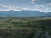 Feldweg durch rumänische Landschaft mit Bergen im Hintergrund