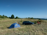 Audi A4 mit Zelt und Campingstuhl auf trockener Wiese
