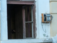 Öffentliches Telefon neben offenem Fenster