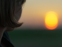 Frau blickt in Sonnenuntergang