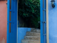Offene, blau bemalte Tür in Mauer