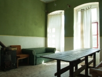 Lost Place, Grün angemaltes Zimmer mit Tisch und Couch