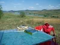 Campingtisch mit Karte, Reiseführer und Schreibzeug
