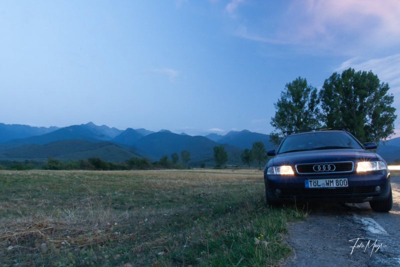 Audi A4 mit eingeschalteten Lichtern vor Bergpanorama