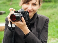 Frau mit Nikon Kamera lächelt in die Kamera