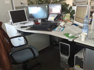Schreibtisch mit vier Bildschirmen