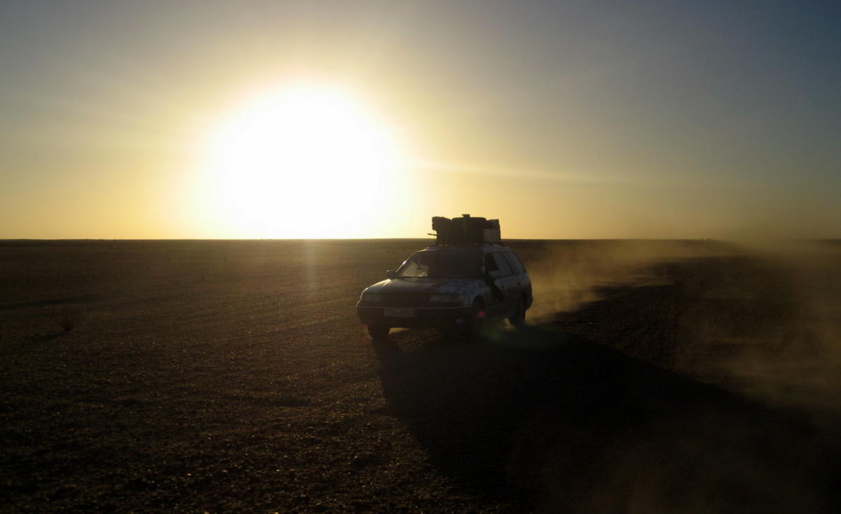 Subaru auf der Piste in der Wüste im Sonnenuntergang