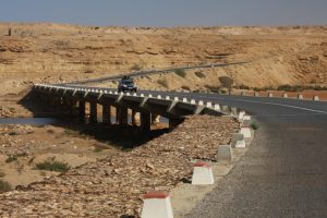 Straße mit Talbrücke mit Subaru in der Westsahara