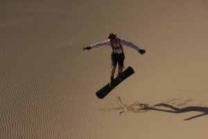 Sandboarden auf einer Sanddüne in der Westsahara