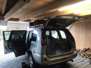 Nissan X-Trail mit geöffneten Türen in Carport