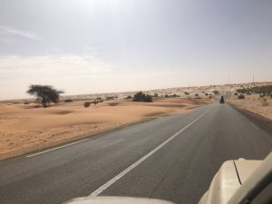 Straße mit Sandverwehungen durch die Wüste
