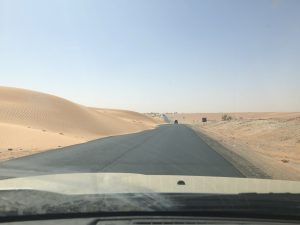 Straße mit Sandverwehungen durch die Wüste