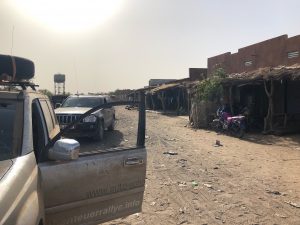 Geländewagen in afrikanischer Siedlung